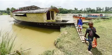  ??  ?? Students leaving a ‘floating school’, operated by Shidhulai Swanirvar Sangstha (SSS), in Chalan Beel in Rajshahi district.