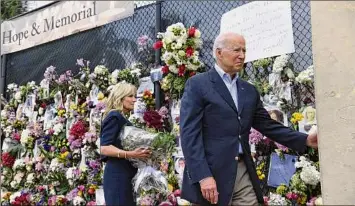  ?? Saul Loeb / Getty Images ?? President Joe Biden and first lady Jill Biden visit the “Surfside Wall of Hope & Memorial” near the partially collapsed Champlain Towers South condo building in Surfside, Fla., Thursday. The president flew to Florida to “comfort” families of people killed or still missing.