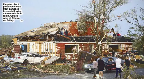  ?? AP ?? People collect personal effects from damaged homes following a tornado in Dunrobin, Ontario west of Ottawa on Friday.