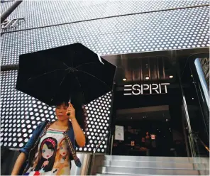  ??  ?? A woman walks outside the biggest Esprit store in Hong Kong. The retailer reported a more-than-threefold rise in full-year profit. (Reuters)