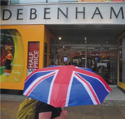  ??  ?? A shopper walks past a Debenhams store in central London. The department store chain has warned on profits following a tough festive period. (Reuters)