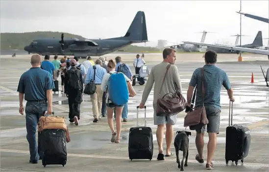  ?? Carolyn Cole Los Angeles Times ?? PASSENGERS on a Sept. 15 flight leaving St. Croix in the U.S. Virgin Islands, after Hurricane Irma canceled and delayed thousands of flights earlier in the month.