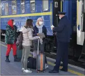  ?? EFREM LUKATSKY — THE ASSOCIATED PRESS ?? A train conductor checks the COVID Certificat­e of passengers, at a train station in Kyiv, Ukraine on Tuesday. Coronaviru­s infections and deaths in Ukraine have surged to all-time highs amid a laggard pace of vaccinatio­n, which is one of the lowest in Europe.