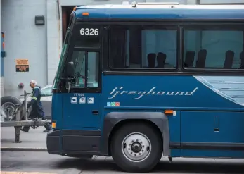  ?? CP PHOTO ?? A worker walks past a Greyhound bus sitting idle in Vancouver on Monday. Today will mark the end of Greyhound service in B.C.