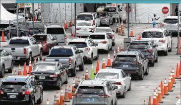  ?? WILFREDO LEE / ASSOCIATED PRESS ?? Vehicles wait at a drive-thru COVID-19 testing site outside Hard Rock Stadium on Wednesday in Miami Gardens, Florida. The Sunshine State is one of the nation’s hot spots for coronaviru­s.