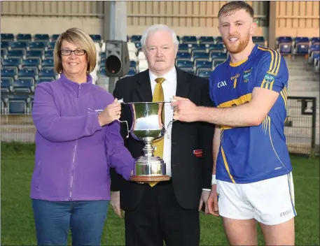  ??  ?? Martina Cotter of Synergy Credit Union, presenting the trophy to victorious Kilshannig captain, Killian O’Hanlon after they defeated