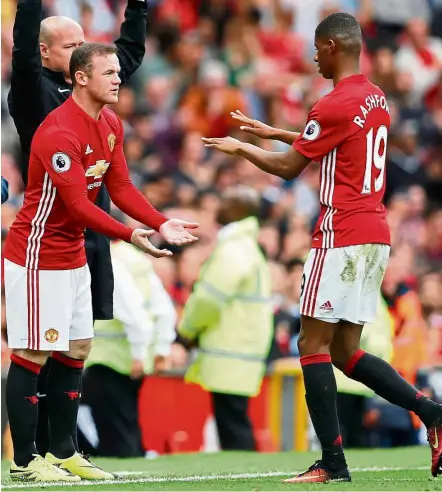  ?? — Reuters ?? Unfamiliar role: Manchester United’s Wayne Rooney (left) coming on as a substitute to replace Marcus Rashford in the English Premier League match against Leicester at Old Trafford on Saturday.