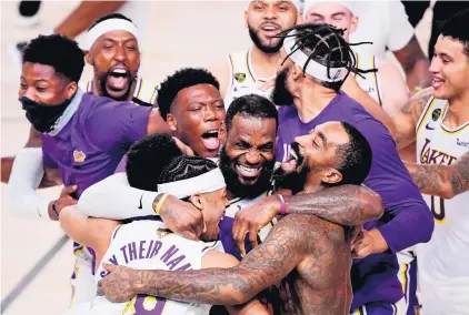  ?? DOUGLAS P. DEFELICE/GETTY IMAGES ?? LeBron James, center, celebrates with Quinn Cook, left, and a shirtless J.R. Smith after the Lakers won the NBA championsh­ip Sunday.