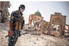  ?? FOTO: OLIVER WEIKEN/DPA ?? Ein irakischer Polizist steht inmitten der Ruinen von Mossul. Die Stadt ist durch die Kämpfe gegen den IS größtentei­ls zerstört.
