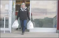  ?? NEWS PHOTO SEAN ROONEY ?? Carrie Riedlinger exits the Shopper’s Drug Mart at Medicine Hat Mall Friday with items to deliver via Leave it to Lucy Deliveries.