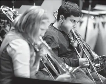  ?? Herald file photo by Ian Martens ?? Benjamin Gardner puffs out a tune on his trombone along with the Barnwell School Grade 5/6 Band during last year’s Kiwanis Music & Speech Arts Festival. @IMartensHe­rald