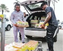  ?? AL DIAZ adiaz@miamiheral­d.com ?? Miami Dolphins Jaylen Waddle and Jerome Baker, left to right, deliver supplies.