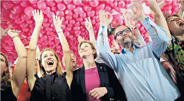  ??  ?? Members of The New Austria and Liberal Forum react after last night’s exit polls. Below, Sebastian Kurz and his girlfriend Susanne Thier on their way to vote in Vienna yesterday