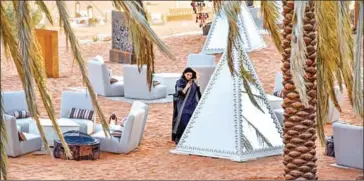  ?? AFP ?? A woman checks her phone in an outdoor seating area at the ‘Riyadh Oasis’, a luxury retreat in the Thumamah desert on the outskirts of the Saudi capital on February 1.