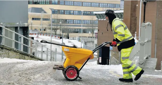  ?? PETER BOLTER ?? A Bridgend Council worker clearing snow in the centre of the town in the aftermath of Storm Emma