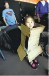  ??  ?? Left: Anaya Mathys, 4, makes like a package during a packing party for deployed military personnel at Municipal Stadium in San Jose.