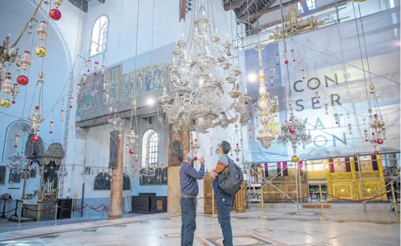  ?? AP ?? Tourists visit the Church of the Nativity in the West Bank city of Bethlehem on Tuesday. The Church of the Nativity, built on the spot where Christians believe Jesus was born, is wrapping up a three-year restoratio­n project just in time for the normally busy Christmas season.