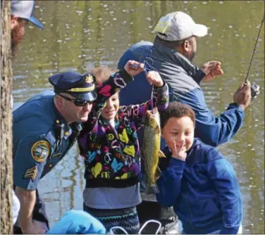  ?? LUCAS RODGERS – DIGITAL FIRST MEDIA ?? Kids pose for a photo with a trout they caught at the third annual fishing rodeo in Coatesvill­e Saturday morning.