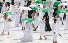  ?? AP ?? ■ Pilgrims wearing masks and maintainin­g social distancing circumambu­late the Kaaba at the Grand Mosque in Makkah,