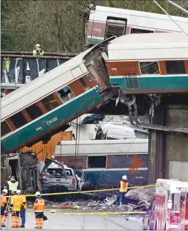  ?? Associated Press photos ?? Cars from an Amtrak train that derailed lay spilled onto Interstate 5 alongside smashed vehicles Monday in DuPont, Wash. The Amtrak train making the first-ever run along a faster new route hurtled off the overpass Monday near Tacoma and spilled some of...