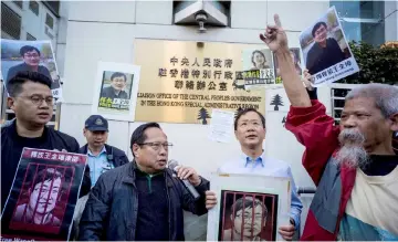  ??  ?? Veteran pro-democracy lawmaker Albert Ho (centre left) speaks as fellow activists chant slogans and hold placards of Wang at a rally outside the Chinese Liaison Office in Hong Kong as Wang’s trial is set to begin in China. — AFP photo