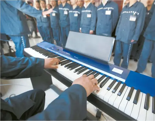  ??  ?? Chorus singers, all inmates of Tilanqiao Prison, practice a popular Chinese song about friendship, but the lyrics have been rewritten to reflect life as a prisoner — separated from loved ones, ostracized by the public and suffering from the slow...