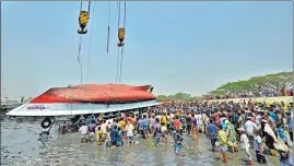  ?? AFP ?? Onlookers and relatives gather after the boat was recovered in Narayangan­j near Dhaka.