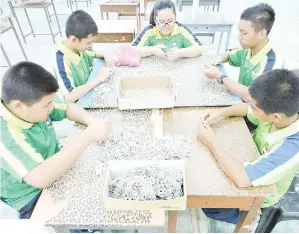  ??  ?? SEBAHAGIAN pelajar yang menghadiri aktiviti menganyam penutup tin secara bergotong royong di dewan sekolah.