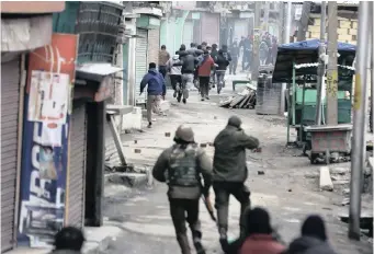  ??  ?? INDIAN police chase Kashmiri Muslim protesters during clashes that erupted after a raid on the house of Mohammad Yasin Malik, chairperso­n of the Jammu Kashmir Liberation Front, in Maisuma, Srinagar. |