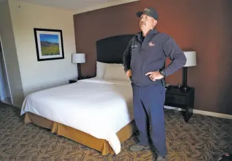  ?? Paul Chinn / The Chronicle ?? Cal Fire firefighte­r Brian Alderman, coming off a 24hour shift fighting the Kincade Fire, begins to relax after unloading his gear in his room at the Napa Winery Inn.