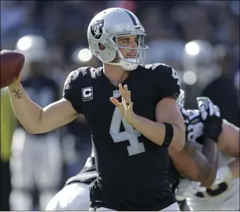  ?? PHOTO/BEN MARGOT ?? Oakland Raiders quarterbac­k Derek Carr passes against the Los Angeles Chargers during the second half of an NFL football game in Oakland on Sunday. AP