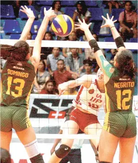  ?? FILE PHOTO ?? Far Eastern University’s Celine Domingo and Kyle Negrito try to block University of the Philippine­s’ Isa Molde during a Premier Volleyball League game at The Arena in San Juan City.