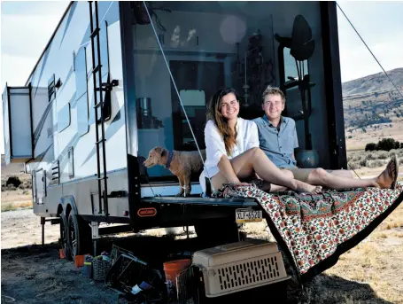  ?? CITIZEN NEWS SERVICE PHOTO BY KIM RAFF ?? Mandy and Kevin Holesh relax with one of their two dogs at their RV. They were parked last week at Utah Lake in Saratoga Springs, Utah, far from their previous home in Pittsburgh. An app he created several years ago helps people pull away from constant...