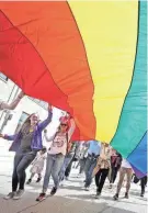  ?? MIKE DE SISTI / MILWAUKEE JOURNAL SENTINEL ?? A group carries a Pride flag during the Milwaukee Pride Parade in Milwaukee on June 5, 2022.