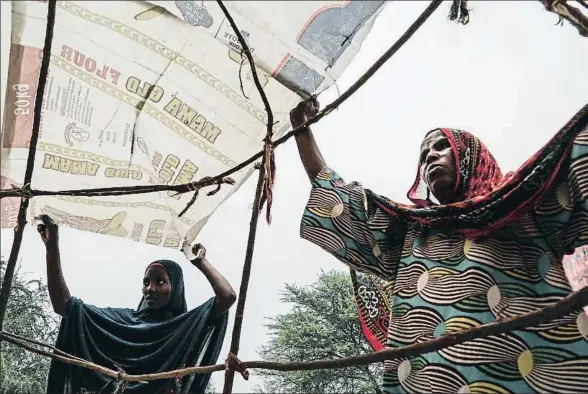  ?? XAVIER ALDEKOA ?? Fatima (derecha) y su hija Fatime (izquierda), refugiadas que huyeron de Boko Haram, montan su tienda en Maiduguri