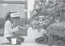  ?? Michael Ciaglo / Houston Chronicle ?? Lieder Elementary first-grader Melanie Gallegos writes down words she found on a Christmas tree.