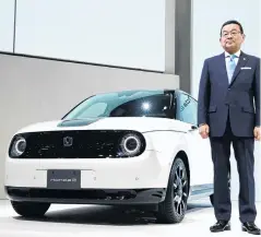  ??  ?? Honda chief executive Takahiro Hachigo next to the Honda e electric car.