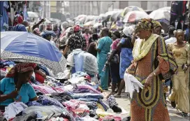  ?? SUNDAY ALAMBA / AP ?? Pedestrian­s shop Friday in Lagos, Nigeria. The African Union continenta­l body said it was “frankly alarmed” by President Donald Trump’s comments. South Africa’s ruling African National Congress called Trump’s comments “extremely offensive.”