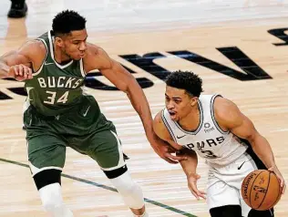  ?? Morry Gash / Associated Press ?? The Spurs’ Keldon Johnson drives past the Bucks’ Giannis Antetokoun­mpo during Saturday’s loss. On Friday, Johnson scored 23 points with a career-high 21 rebounds in a win over Cleveland.