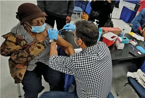  ?? (Pine Bluff Commercial/Eplunus Colvin) ?? Ora Hawkins, 102 years old, receives her covid-19 vaccinatio­n Friday at the Pine Bluff Convention Center.