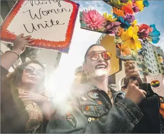  ??  ?? MARY MACINTYRE holds up an LGBT symbol made of f lowers amid the gathering in Los Angeles. Speeakers at the downtown rally included actress Viola Davis, who said she was raising her voice for “all the women who are still in silenc, the women who are...