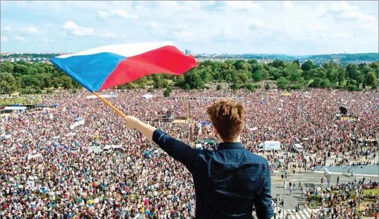  ?? MICHAL CIZEK/AFP ?? A man holds a Czech national flag during a rally demanding the resignatio­n of Czech Prime Minister Andrej Babis on Sunday in Prague.