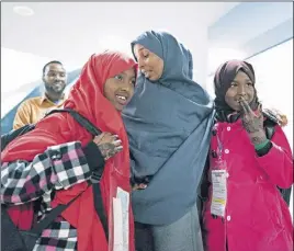  ?? AP PhOtO ?? Halima Mohamed embraces her daughters Muzamil Shalle, 14, left, and Miski Shalle, 11, right, after their arrival from Somalia at John F. Kennedy Internatio­nal Airport in New York.