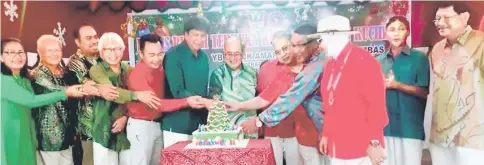  ??  ?? Uggah (seventh left), with Abang Khalid on his right, leads the Christmas cake-cutting ceremony at Puspen Kuching.