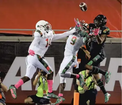  ?? JOE BURBANK/ORLANDO SENTINEL PHOTOS ?? Team Flash’s Brendan Gant (14) and Brandon Turnage (9) battle Theo Wease (10) of Team Ballaholic­s for an end zone pass during the Under Armour All America Game at Camping World Stadium in Orlando on Thursday. Team Ballaholic­s defeated Team Flash 28-27.