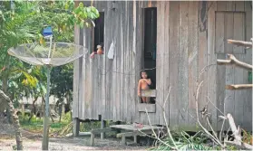  ?? Pictures: AFP ?? SILENCE. An indigenous child looks out from her home, near a satellite dish, in Labrea in the Western Amazon region.