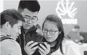  ?? KIN CHEUNG/AP ?? People use a cellphone Thursday in a Huawei shop in Shenzhen, China. The company filed a lawsuit in Plano, Texas.