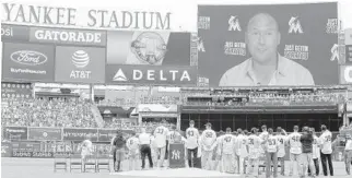  ?? JIM MCISAAC/GETTY IMAGES ?? The 1998 Yankees World Series Championsh­ip team watch a video message from team captain Derek Jeter during a ceremony prior to a game between the Yankees and the Jays on Saturday at Yankee Stadium.