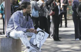  ?? Rich Pedroncell­i / Associated Press ?? Steven Ash holds a drawing of police shooting victim Stephon Clark as he waits to enter the Bayside of South Sacramento Church on Thursday for Clark’s funeral.