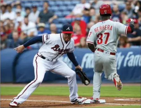  ?? JOHN BAZEMORE — THE ASSOCIATED PRESS ?? The Phillies’ Odubel Herrera is out at first base as what became a 2-1 Braves victory Friday night. Atlanta’s Freddie Freeman does the putout honors in the first inning of